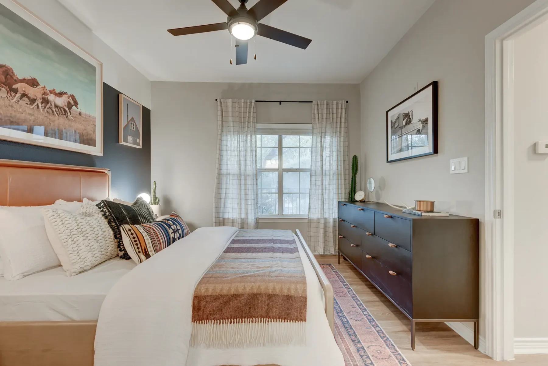 Bedroom with wood-style flooring, window, and ceiling fan