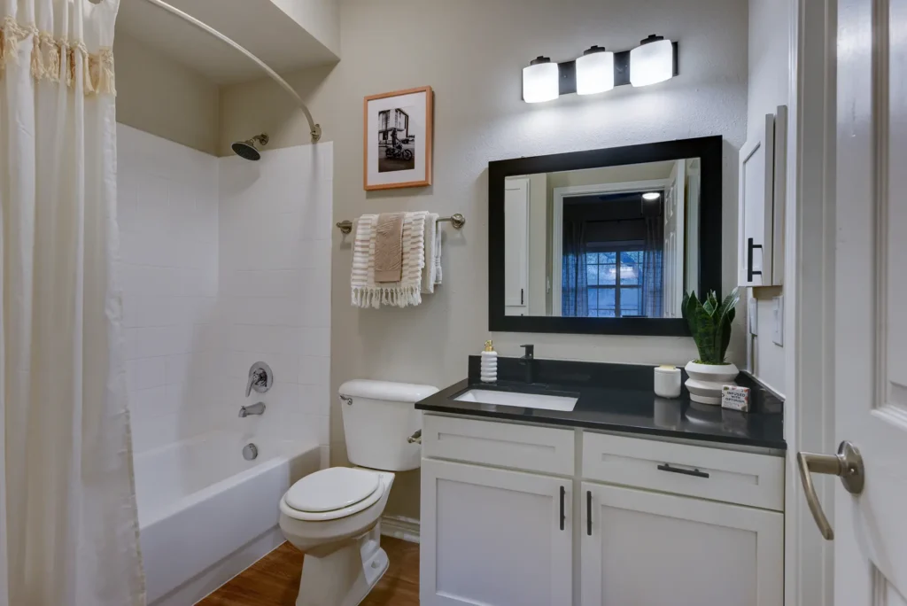 Bathroom with combined shower and tub, and vanity with cabinets and drawer