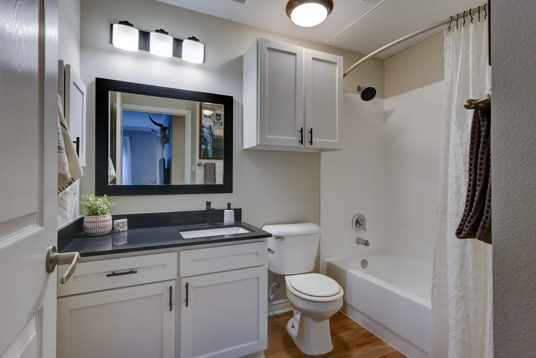 Bathroom with combined shower and tub, and vanity with cabinets and drawer